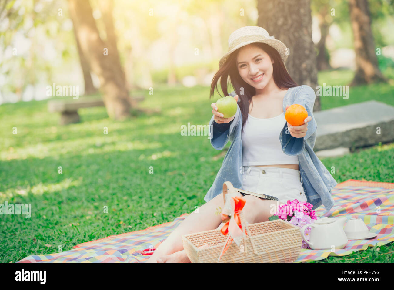 Carino teen dando frutti per mangiare il cibo sano quando picnic parco outdoor concept. Foto Stock