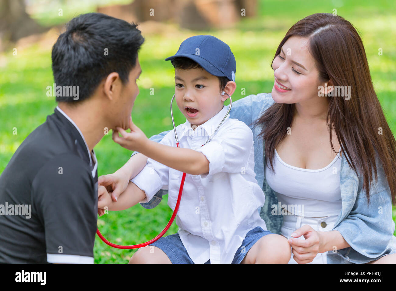 Asian teen famiglia figlio di insegnamento dovere mentre picnic al parco all'aperto Foto Stock