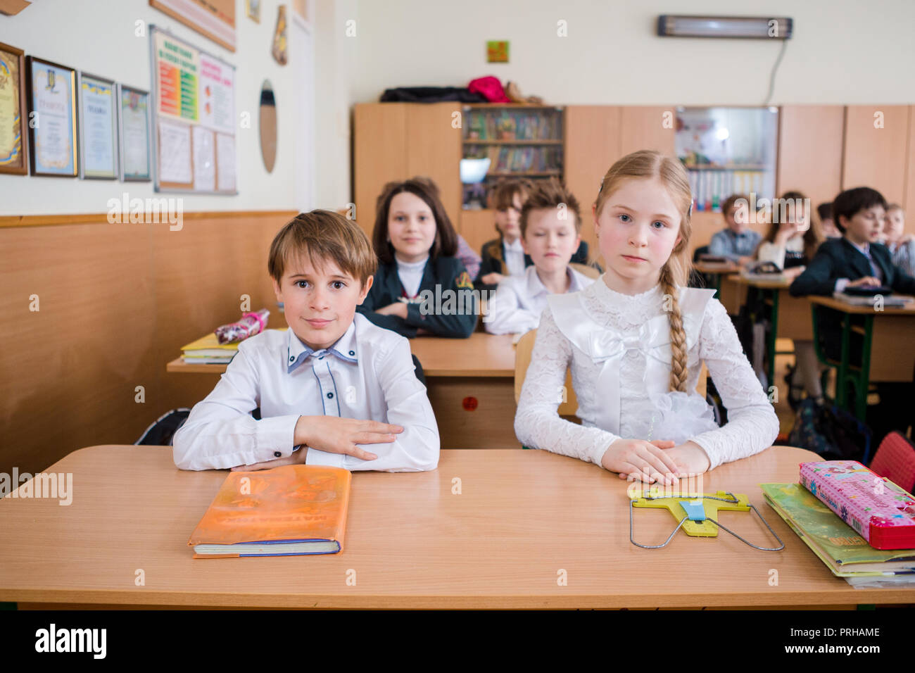 L'Ucraina. Kiev. Il 5 maggio 2018. Scuola Junior, college. Coppia due bambini di nazionalità caucasica, gli alunni di scuola, sit desk classe scuola camera. Sulla tabella libri Foto Stock