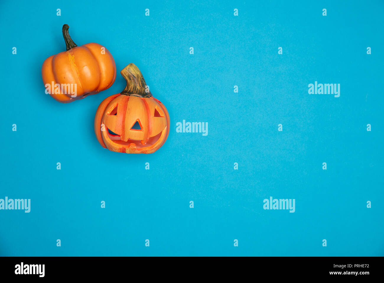 Halloween zucca scolpita divertenti e simpatici volti. Laici piatta contro sfondo blu. Ottobre simbolo Foto Stock