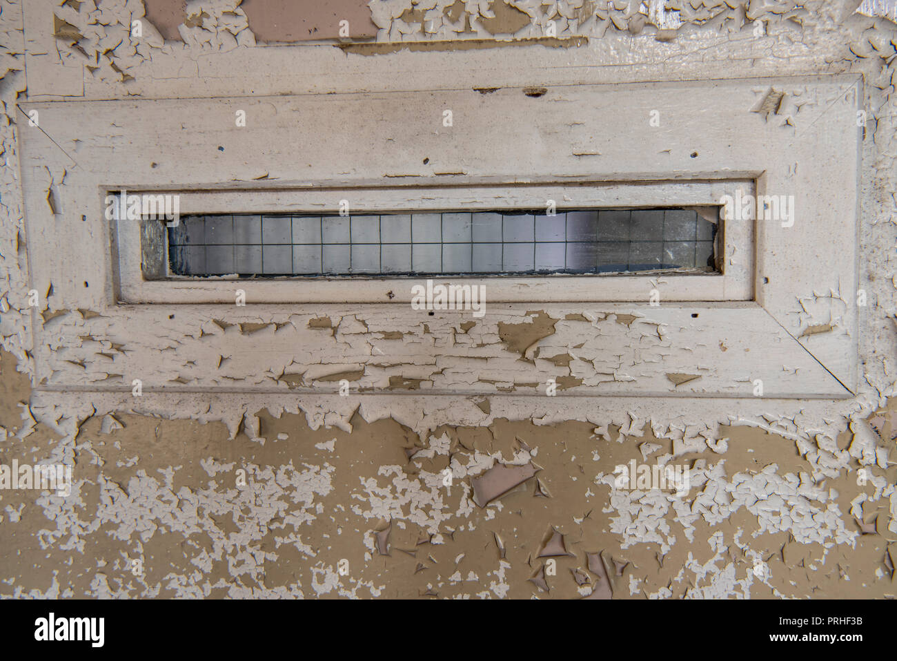 Finestra stretta sulla porta di una cella di prigione con il vecchio, peeling vernice. Foto Stock