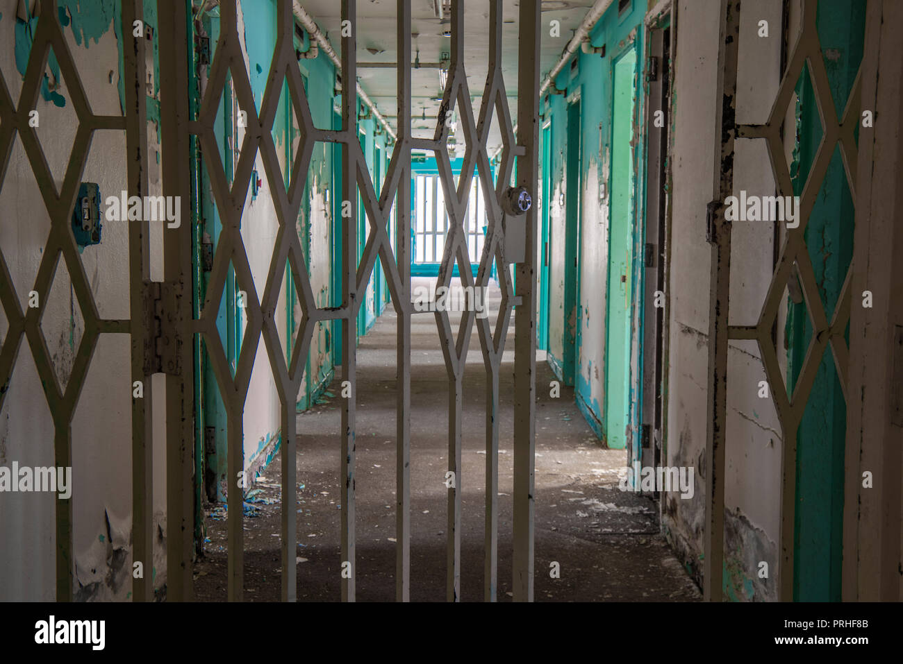 Porta in acciaio attraverso il corridoio della cella di prigione porte all'interno di un carcere abbandonato. Foto Stock