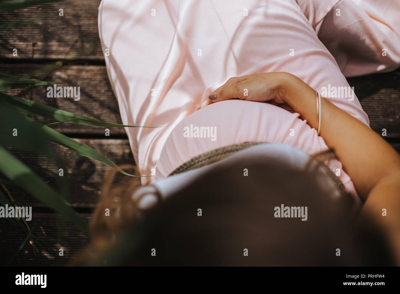 Elevato angolo di visione della donna incinta mentre tiene il suo ventre Foto Stock