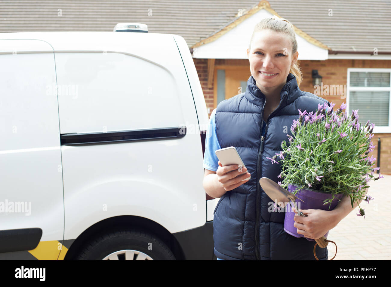 Ritratto di donna in esecuzione il giardinaggio Mobile Business utilizzando il telefono cellulare Foto Stock