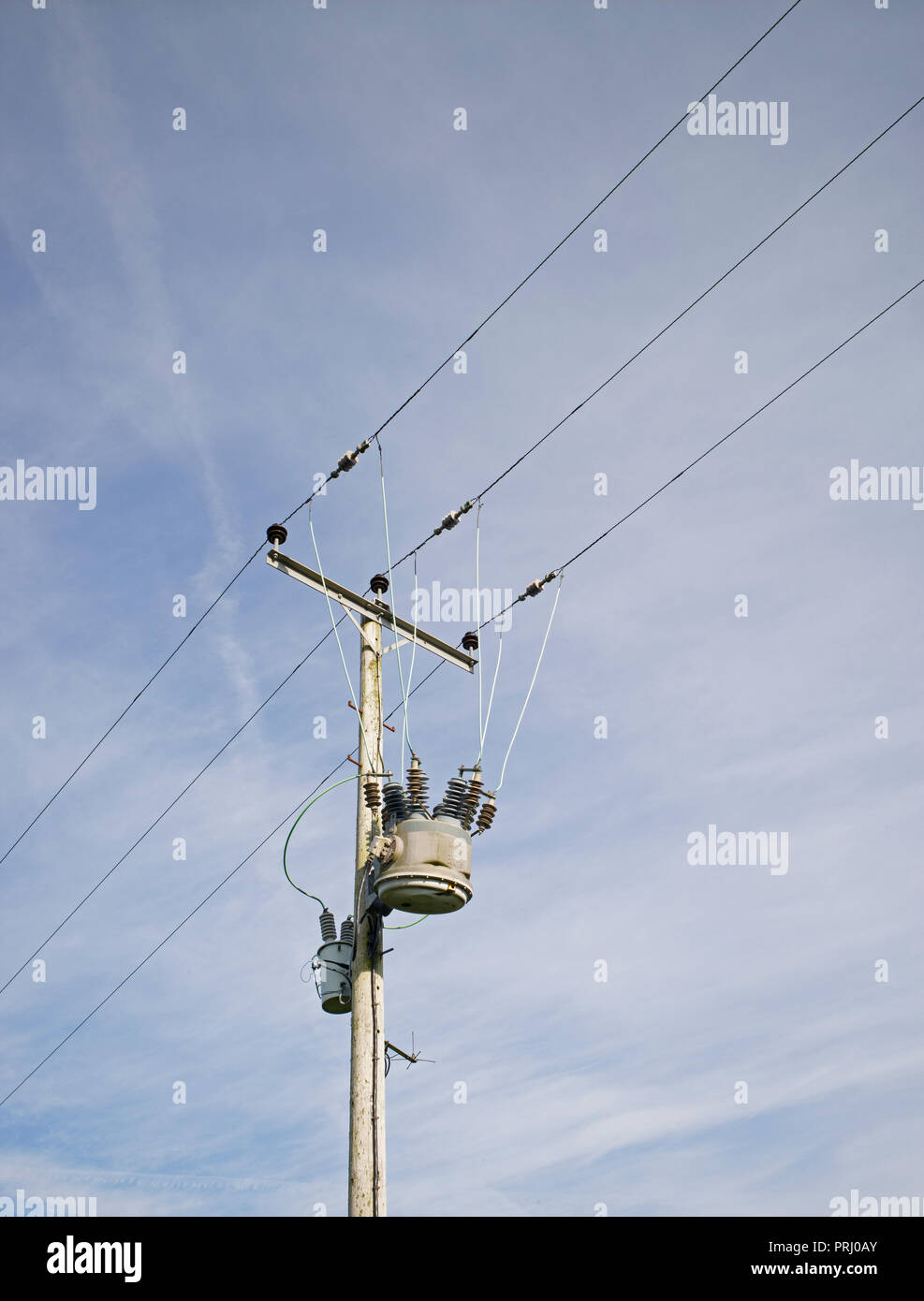 Step-down trasformatori su palo di legno con linee di alimentazione aeree in campagna Foto Stock