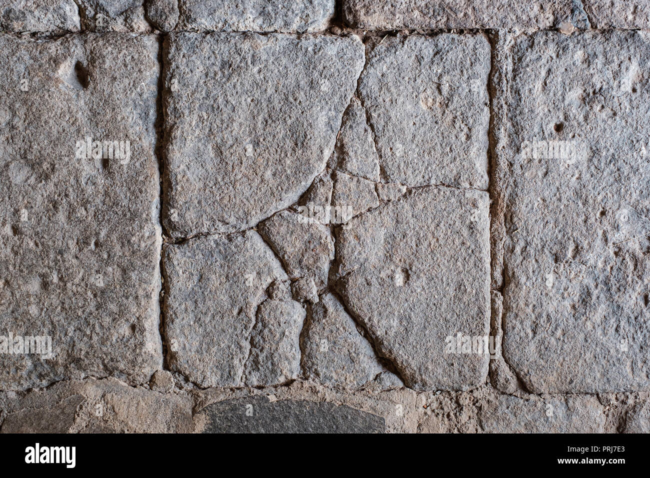 Incrinato in blocchi di pietra, antiche piastrelle del pavimento di pietra / a parete con incrinature - Foto Stock