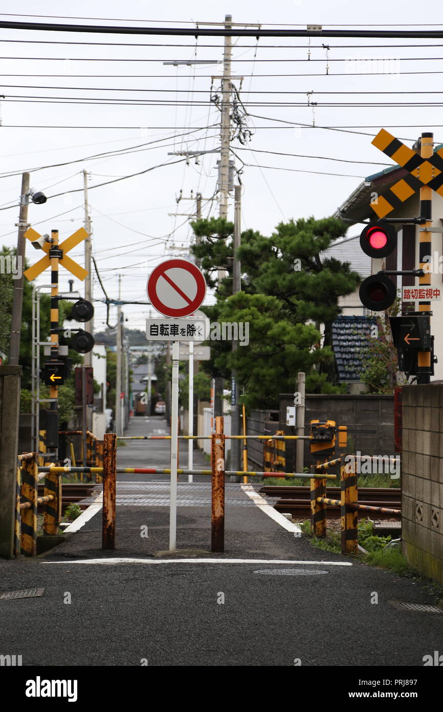 Un attraversamento ferroviario in Giappone. Giapponesi con cartelli stradali Foto Stock