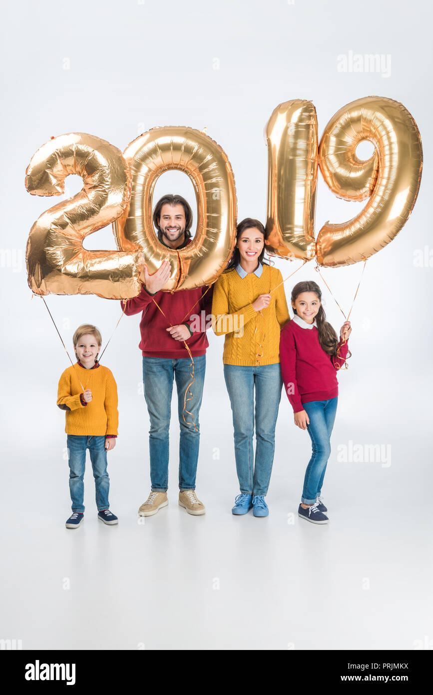 Famiglia sorridente Holding firmano 2019 fatta di golden palloncini per nuovo anno isolato su sfondo bianco Foto Stock