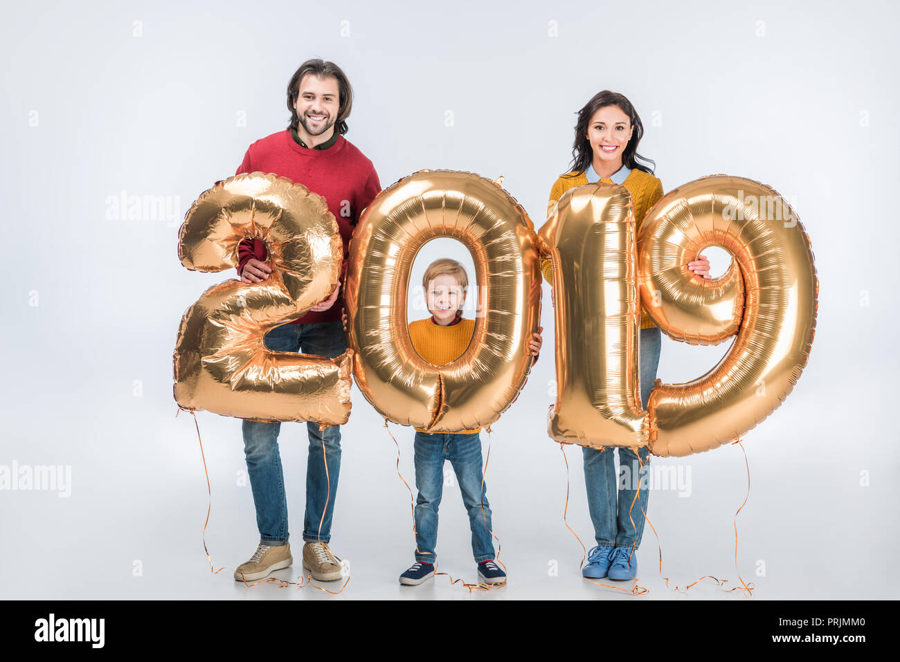 Sorridente genitori con figlio Holding firmano 2019 fatta di golden palloncini per nuovo anno isolato su sfondo bianco Foto Stock