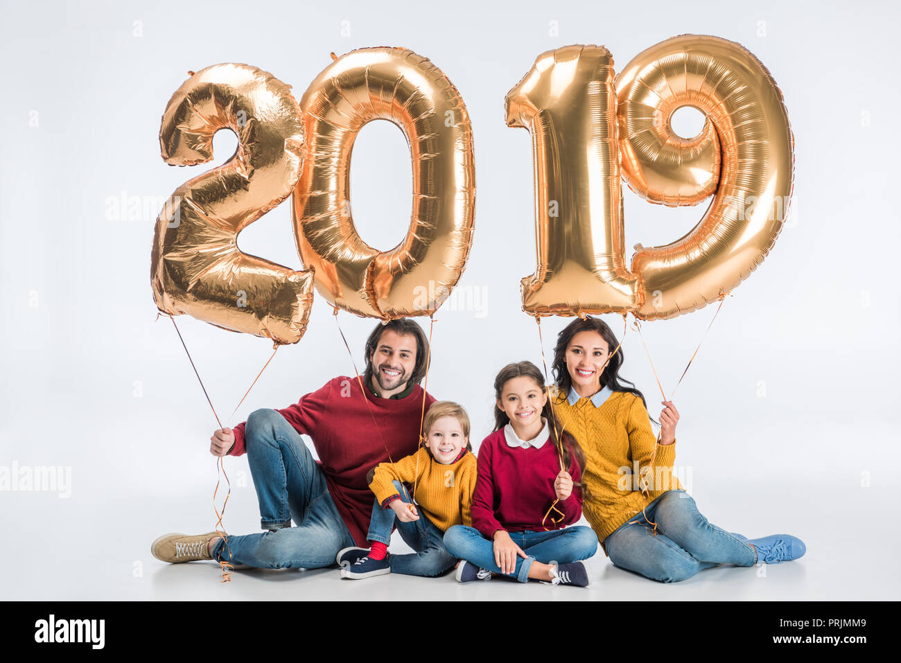 La famiglia felice Holding firmano 2019 fatta di golden palloncini per nuovo anno isolato su sfondo bianco Foto Stock