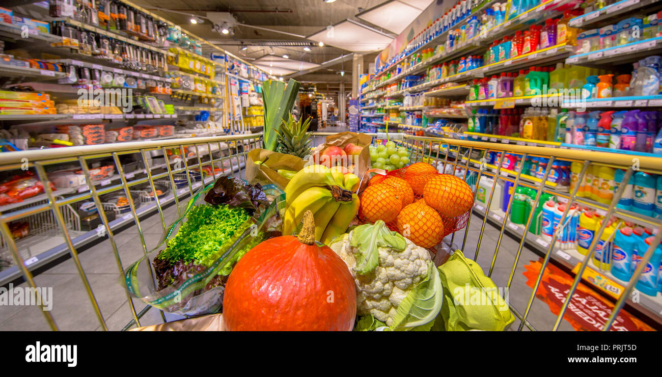 Una sana frutta e verdura in negozio di alimentari carrello nel supermercato riempiti con prodotti alimentari come visto dai clienti punto di vista Foto Stock