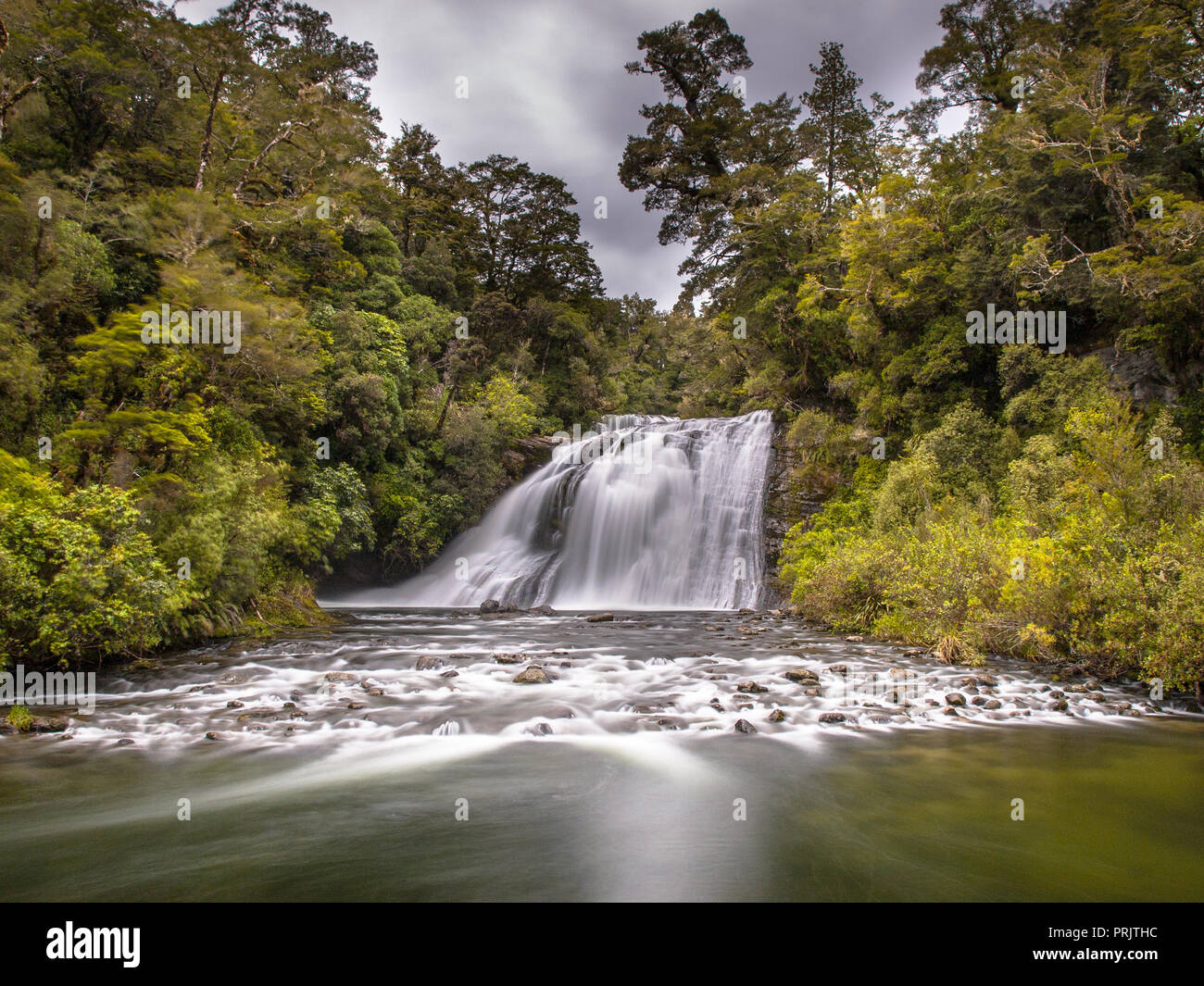 Esposizione lunga cascata di foresta in una lussureggiante foresta pluviale di Te Urewera National Park in Nuova Zelanda Foto Stock