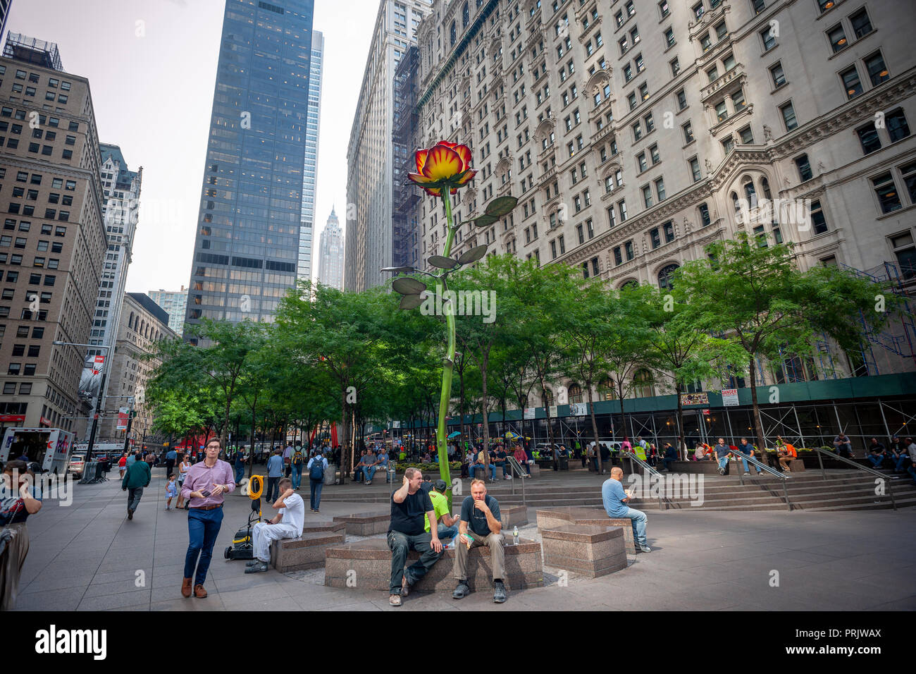 I visitatori e i lavoratori a Zuccotti Park in Manhattan inferiore durante l'ora di pranzo di martedì 2 ottobre, 2018 godere "Rose III' (2016) dall'artista Isa Genzken. Il 26-piede alto fiore, realizzati in acciaio laccato è come prestito a lungo termine per la città di New York e proprietà di Brookfield da collezionista d'arte Lonti Ebers. (Â© Richard B. Levine) Foto Stock