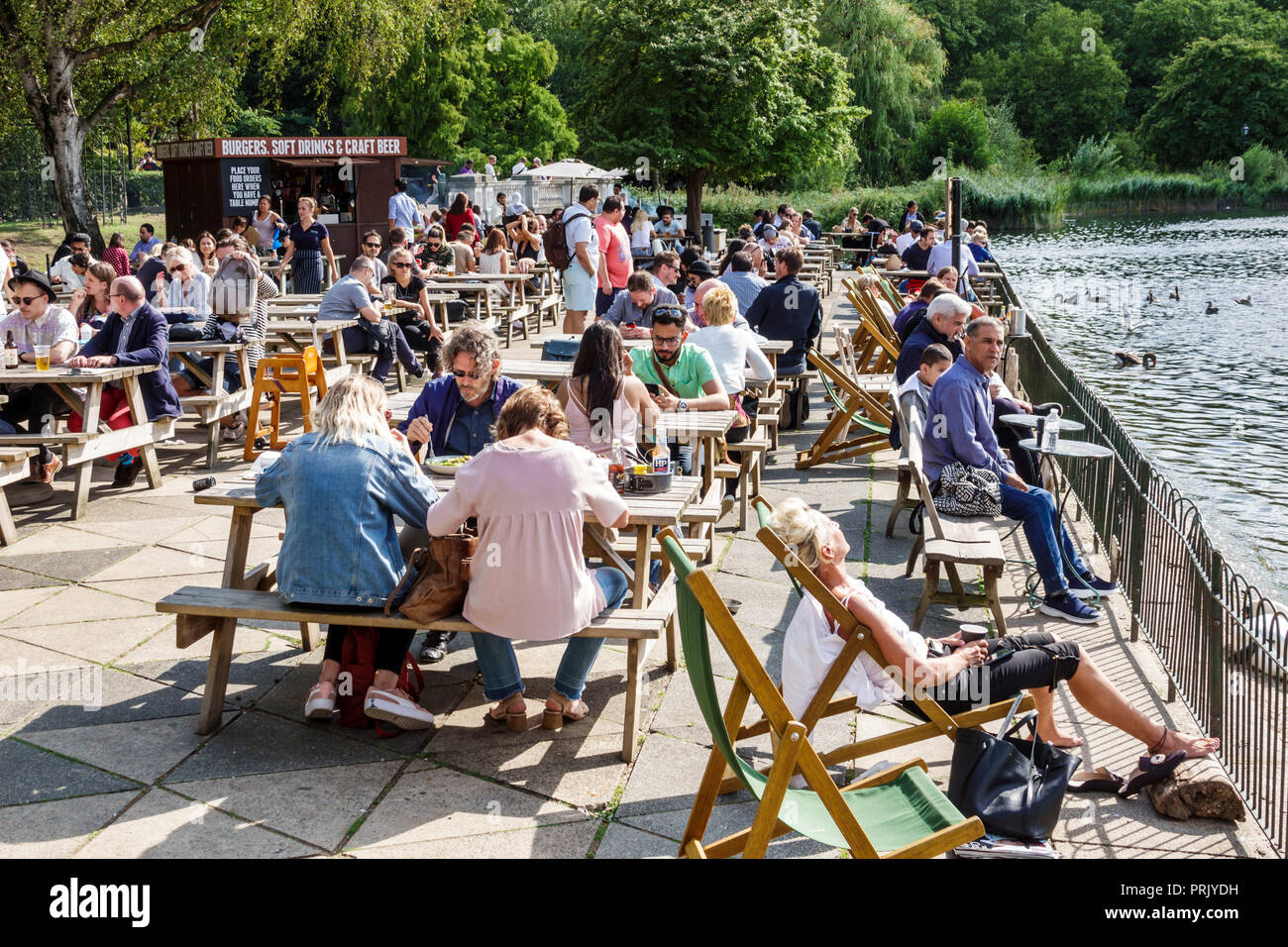 Londra Inghilterra,Regno Unito,Hyde Park Royal Parks,Serpentine Bar & Kitchen,ristoranti ristoranti ristorazione cafe cafe', tavoli da picnic, al fresco, marciapiede esterno Foto Stock