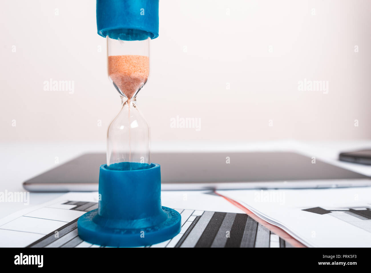 Clessidra. Imprenditore lavora in ufficio in background. Concetto il tempo è denaro. Foto Stock