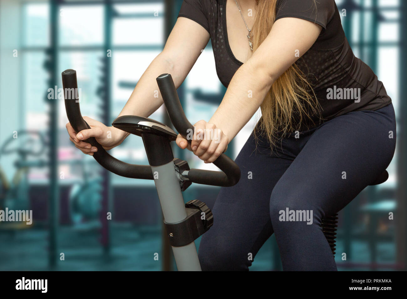 La ragazza di treni in palestra sulla cyclette. Foto Stock