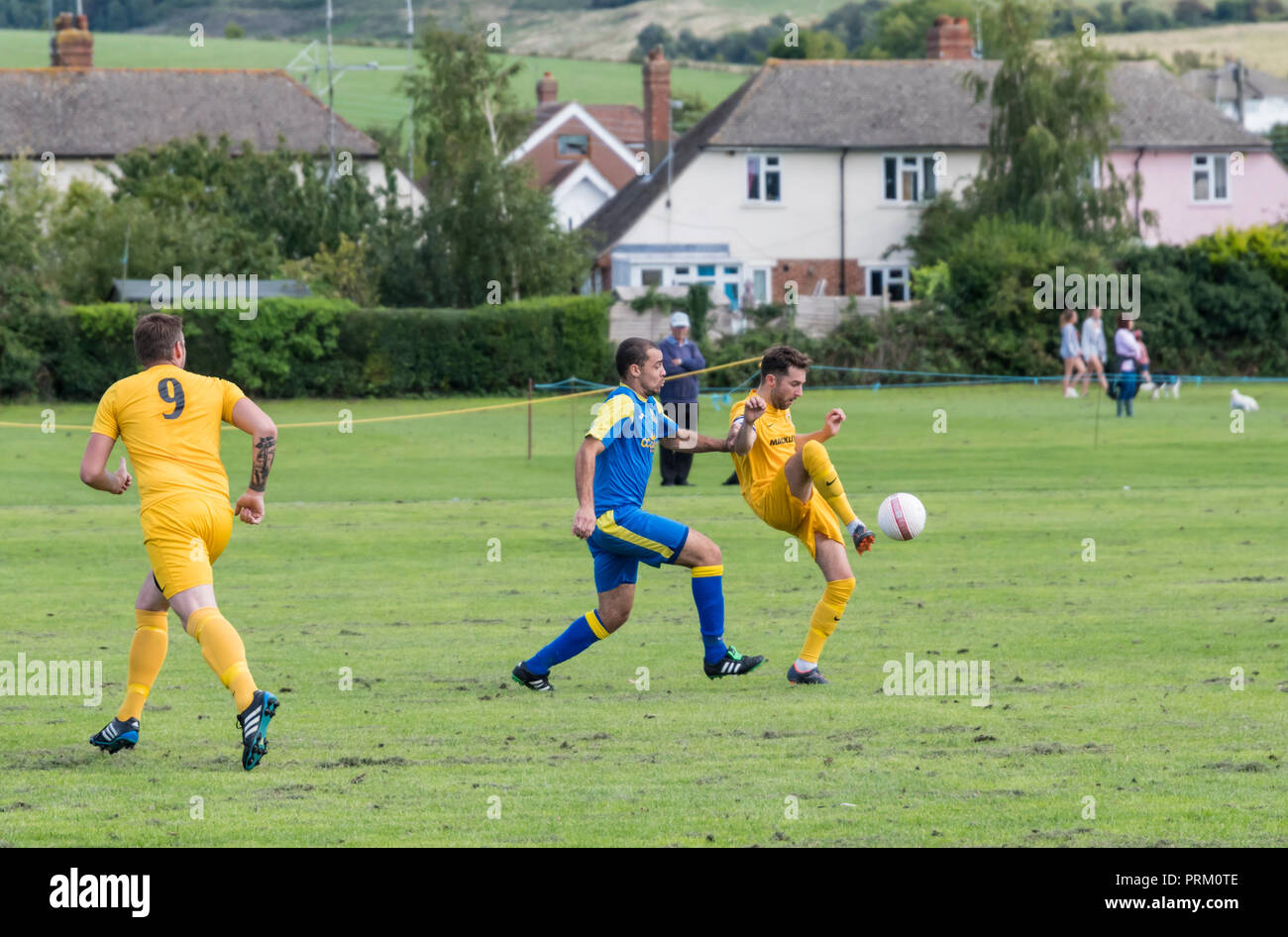 I giocatori di calcio di un pallone durante un sabato league football match con locale squadre amatoriali nel West Sussex, in Inghilterra, Regno Unito. Foto Stock