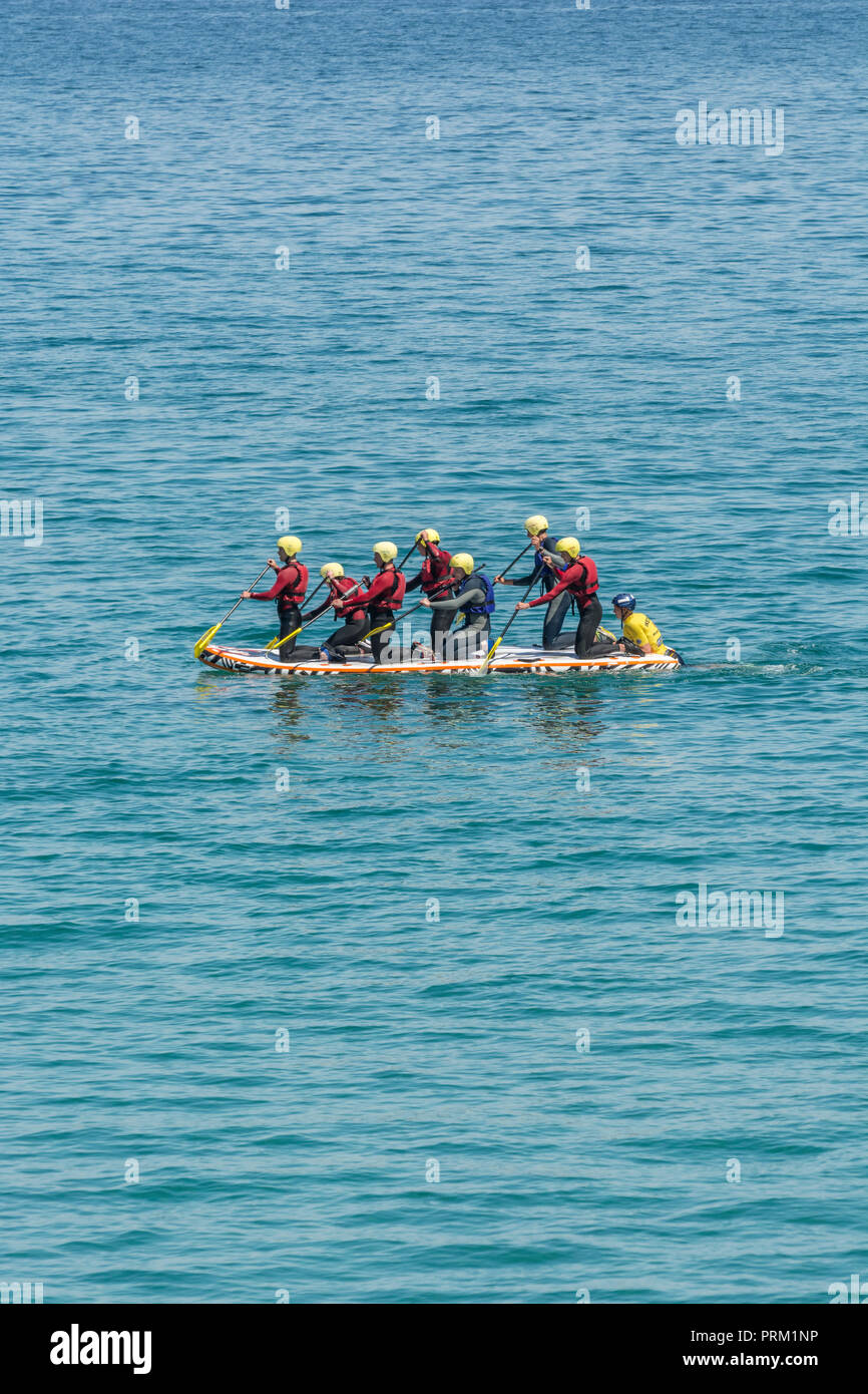 Giant Stand-Up / SUP Paddle Board con gruppo di rematori. Foto Stock