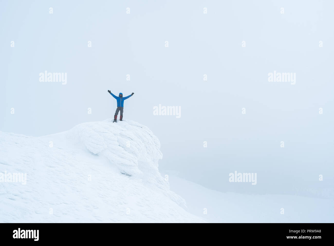 Turisti in montagna. Paesaggio invernale con la nebbia. L uomo sta su roccia Foto Stock