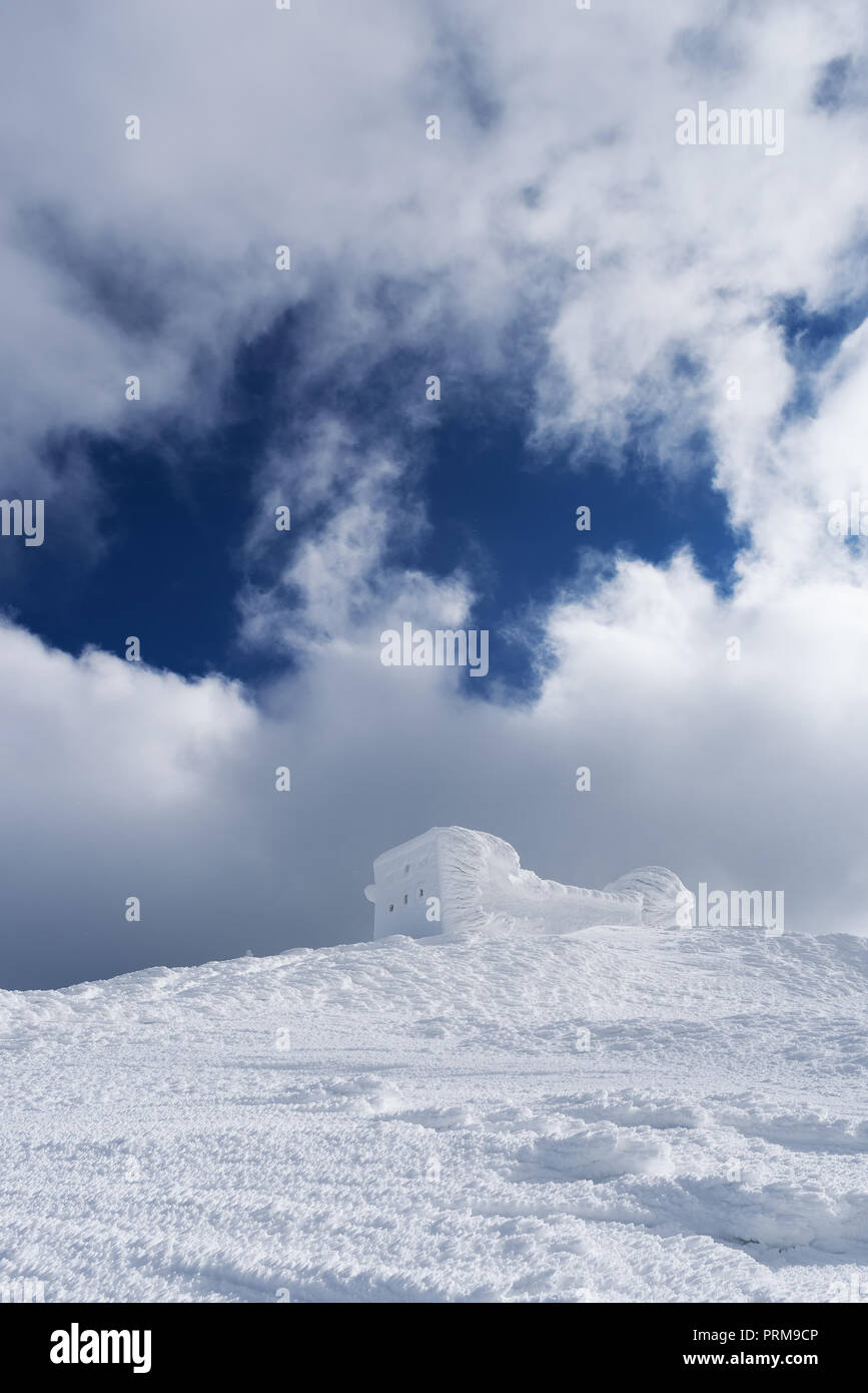 Paesaggio invernale con una bella texture della neve. Il vecchio osservatorio sulla cima della montagna. Giornata di sole. Carpazi, Ucraina, Europa Foto Stock