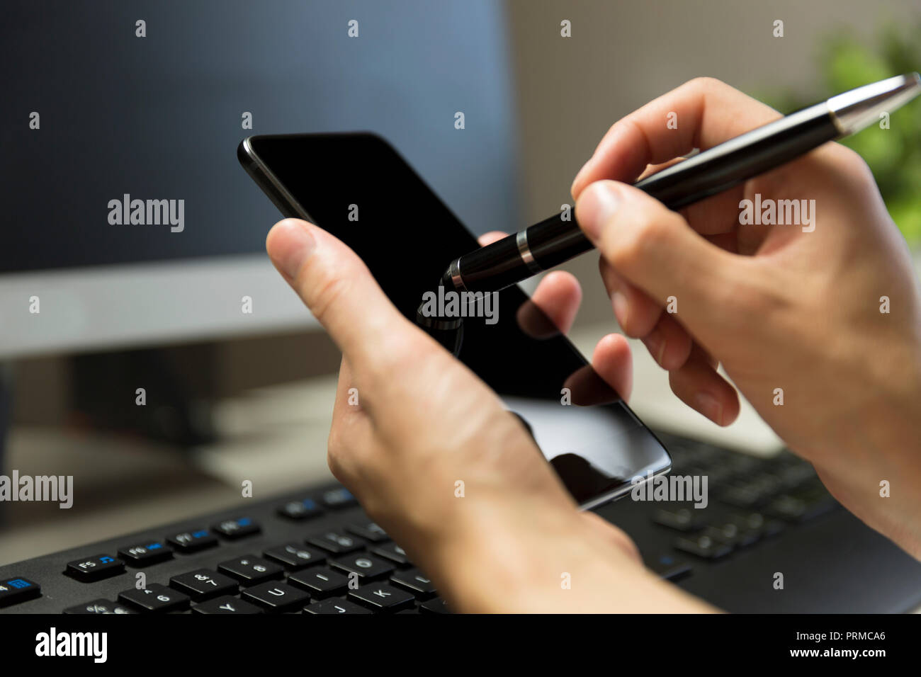 Le mani delle donne tocca lo schermo del telefono con la penna per il touchscreen. Foto Stock
