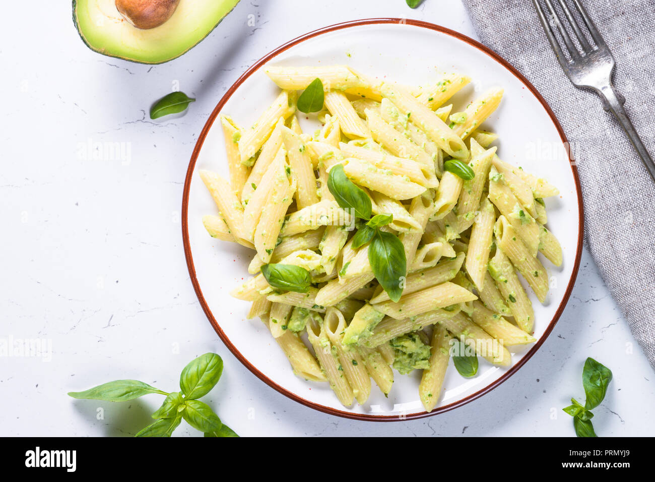 Pasta Vegan pennette con avocado e basilico. Foto Stock