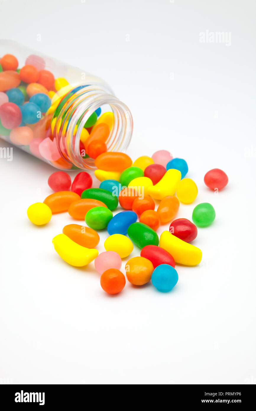 Caramelle di sapori di frutta versato su uno sfondo bianco Foto Stock