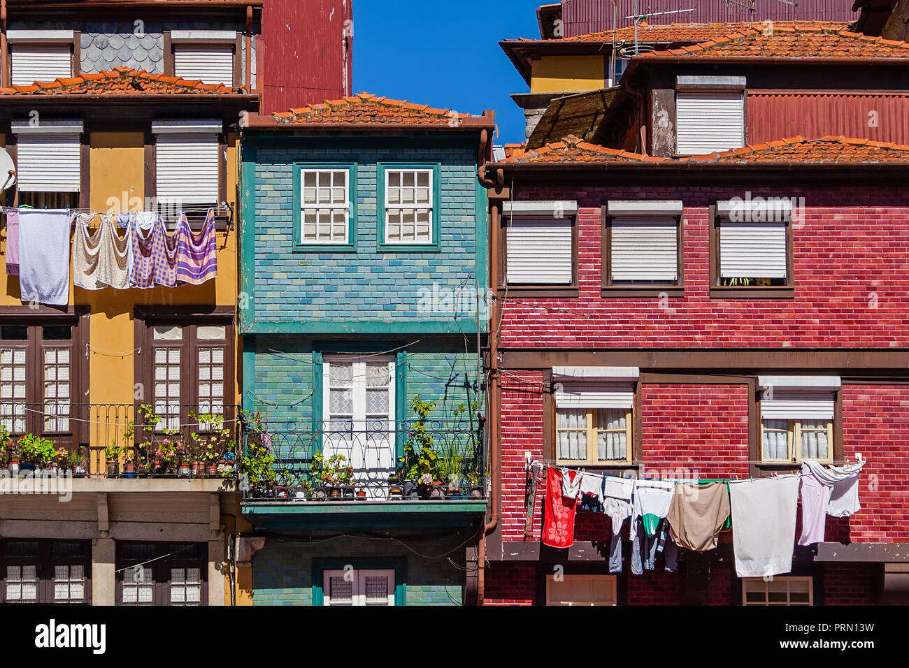Il quartiere Ribeira di Porto o città di Oporto, Portogallo. Tipici edifici colorati, con vestiti appesi in stendibiancheria essiccazione al sole e vasi di fiori in Foto Stock