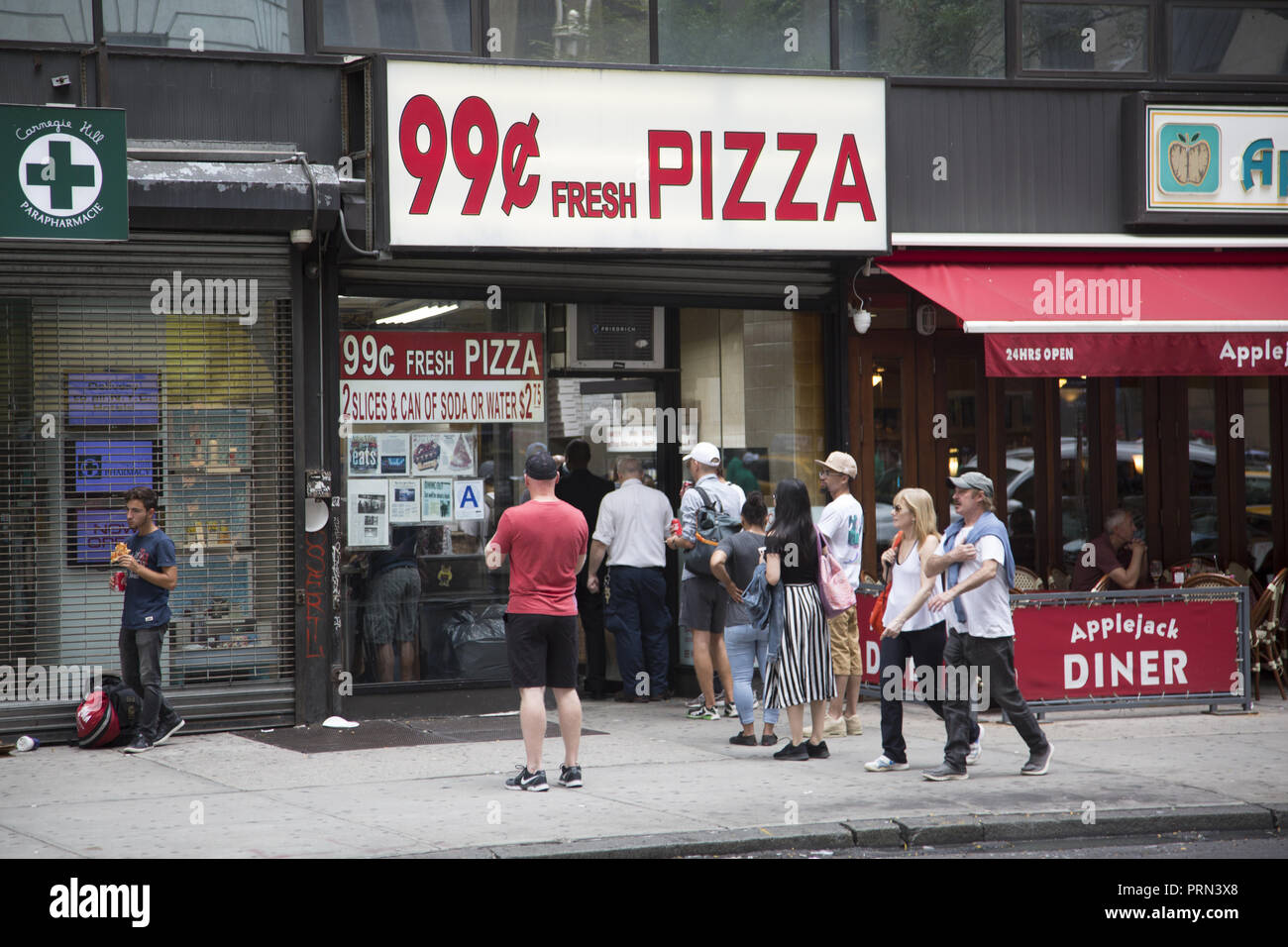 In una città cara come New York di persone in fila per 99¢ pizza. Foto Stock