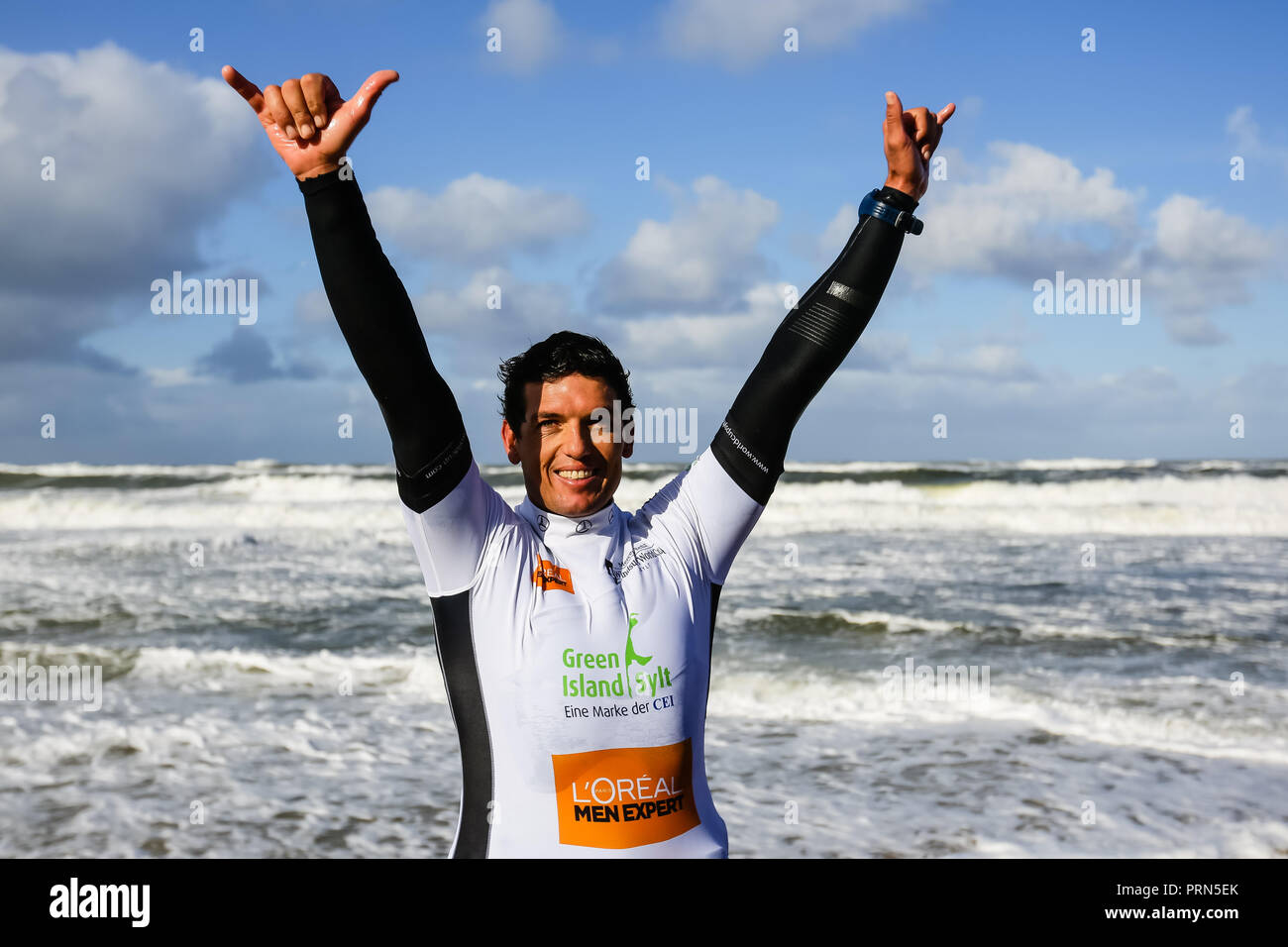 Schleswig-Holstein, Germania. 3° OTT 2018. 03 ottobre 2018, Schleswig-Holstein, Westerland: il nuovo Campione del Mondo di Victor Fernandez cheers con la 'Hang loose' firmare dopo la sua vittoria al Windsurf World Cup in Sylt. Per la terza volta il pilota spagnolo ha vinto il titolo del campionato del mondo in Waveriding. La Mercedes-Benz Windsurf World Cup con un premio in denaro per un totale di 135.000 euro termina il 7 ottobre. Foto: Frank Molter/dpa Credito: dpa picture alliance/Alamy Live News Foto Stock