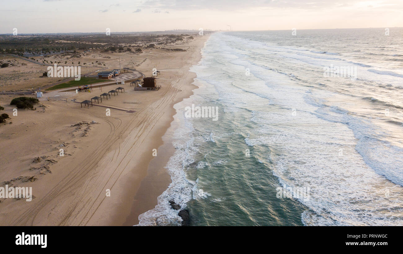 Vista aerea del drammatico vuoto spiaggia sabbiosa con mare ondeggiante, Ashdod, Israele Foto Stock