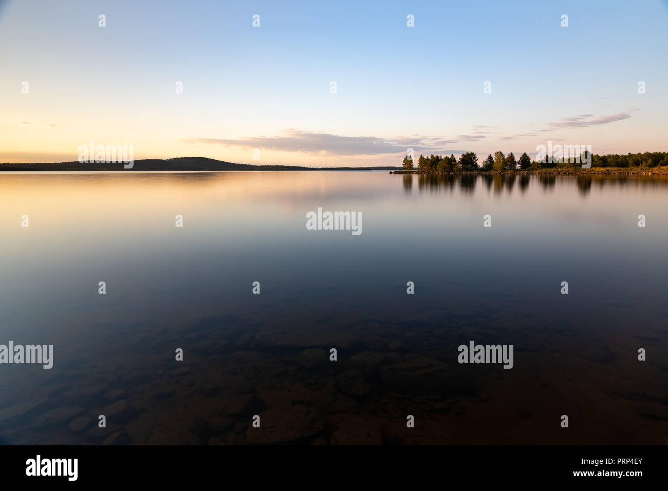 Pietre al di sotto della superficie. Bel Tramonto sul lago Inari in Lapponia, Finlandia Foto Stock