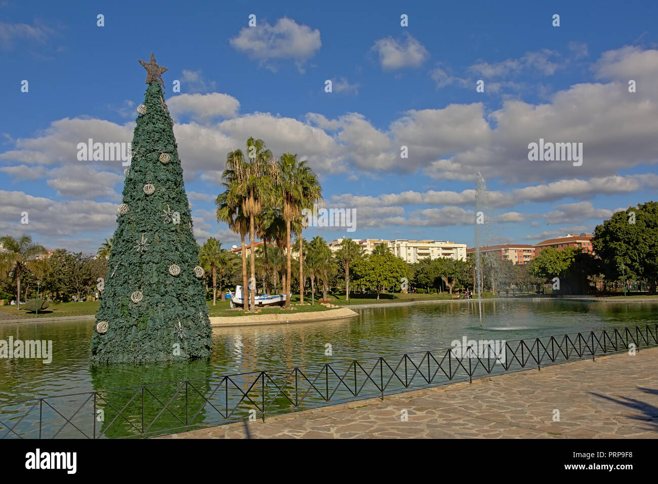 Anteprima Download piscina con fontana, palme e un albero di Natale artificiale in Huelin city Park, Malaga, Sspain Foto Stock
