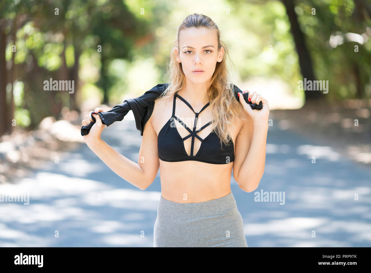 Giovane donna in piedi all'aperto in abito di yoga Foto Stock