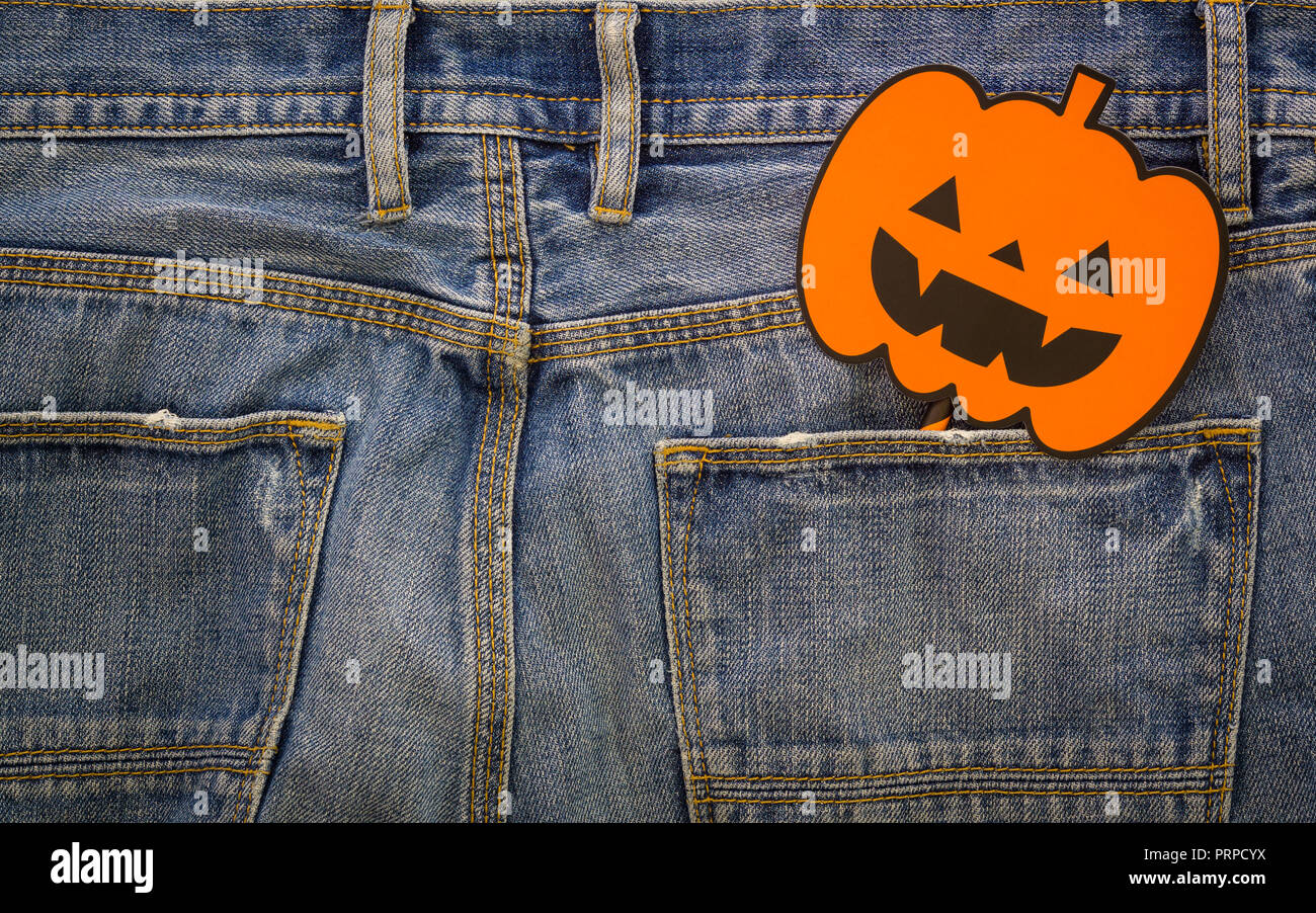 Felice giorno di Halloween. Moda il concetto di sfondo. Vista superiore della zucca di Halloween sign on jeans denim. Foto Stock