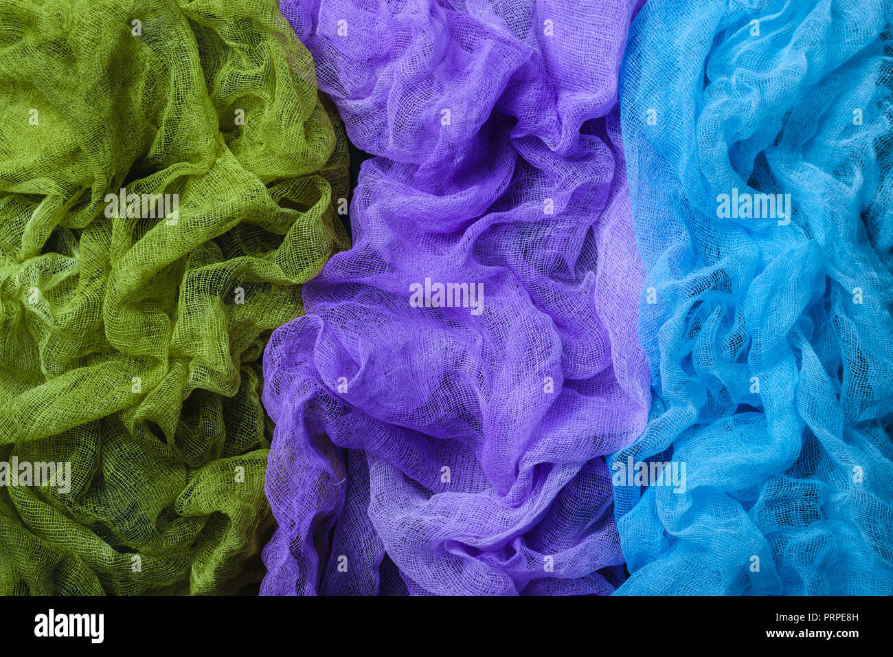 Tinti a mano a trama tessuto di garza di sfondo. Blu, viola e verde. Vista dall'alto. Foto Stock