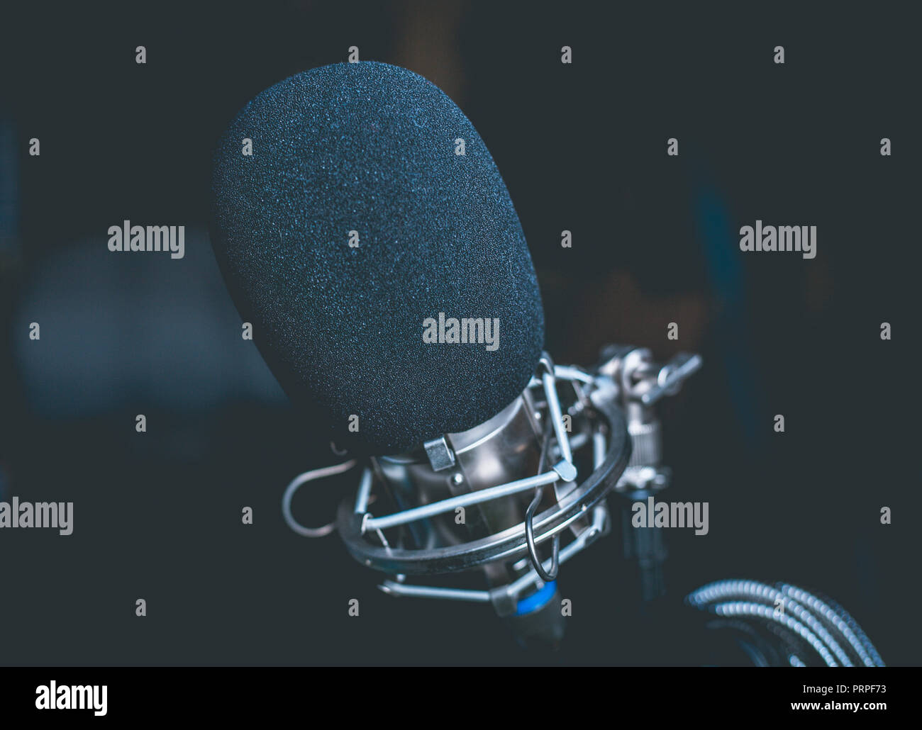 Primo piano di un nero microfono in un garage studio Foto Stock