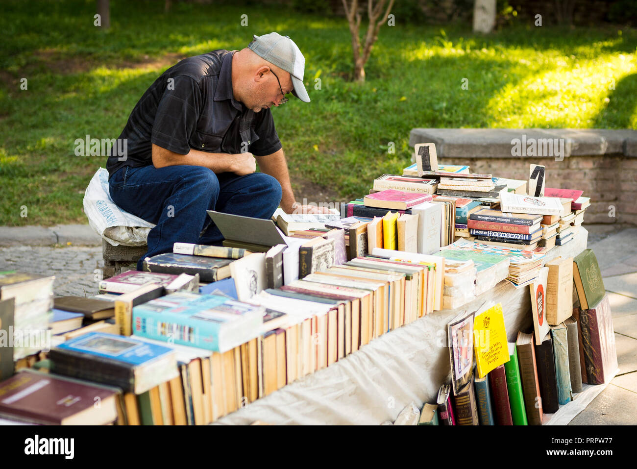 Librai godendo la lettura la loro mercanzia di Tblisi Foto Stock