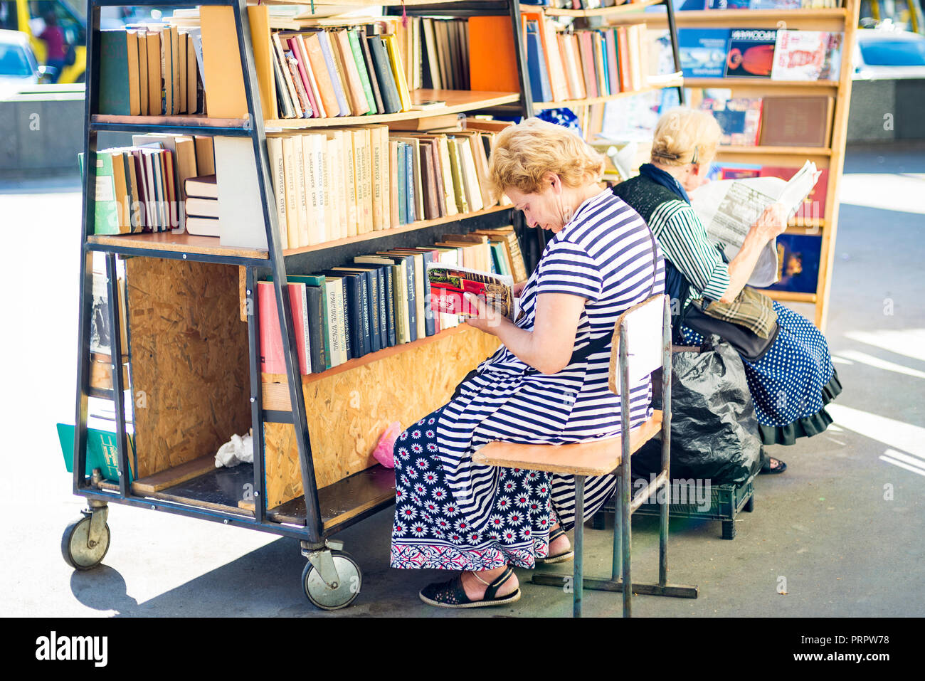 Librai godendo la lettura la loro mercanzia di Tblisi Foto Stock