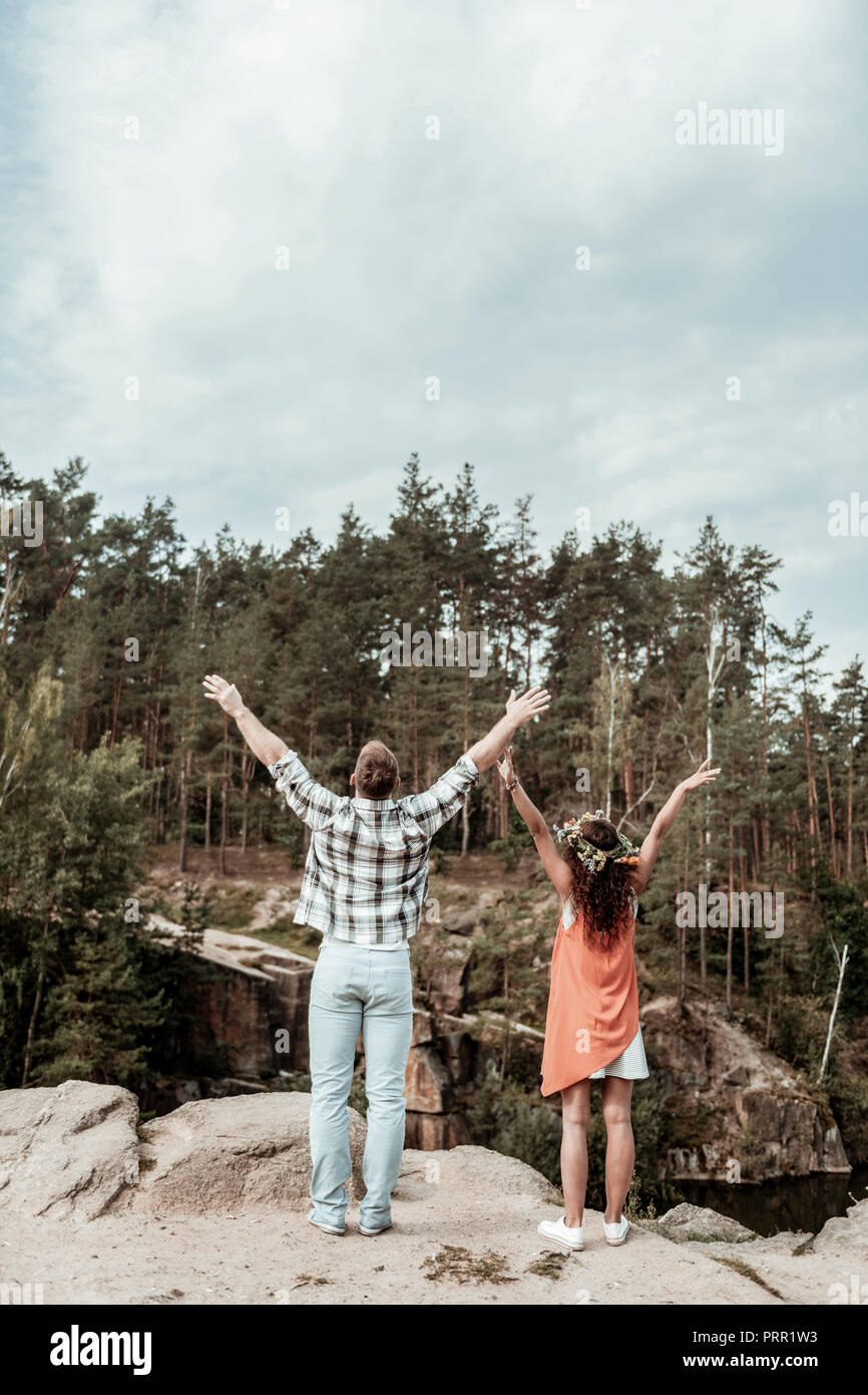 Carino amorevole coppia giovane sentirsi liberi e felici mentre si sta in piedi sul bordo del rock Foto Stock