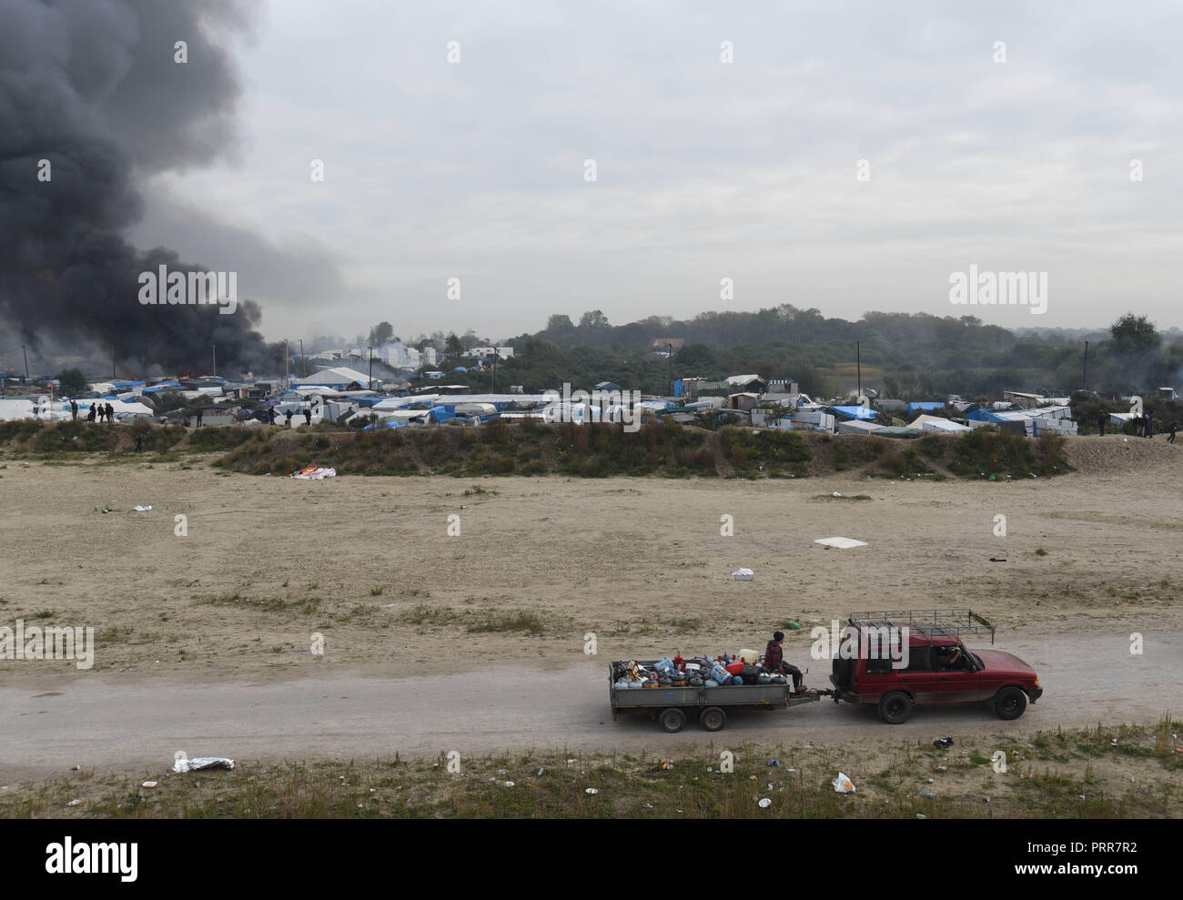 Ottobre 26, 2016 - Calais, Francia: attivisti prendere rimorchio pieno di bombole di gas al di fuori della Calais 'Jungle' accampamento migranti dopo enormi incendi scoppiati nell'accampamento. Demantelement de la jungle de Calais, l'ONU des plus grands camps de migranti au monde. *** La Francia / NESSUNA VENDITA A MEDIA FRANCESI *** Foto Stock