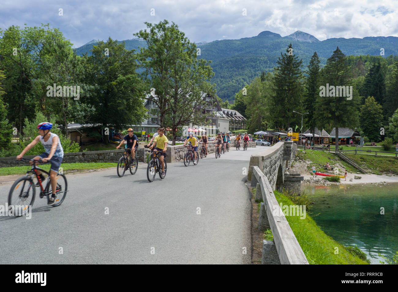 Un gruppo di ciclisti attraversando il ponte di San Giovanni Battista, Rebcev Laz, lago di Bohinj. La Slovenia, Foto Stock