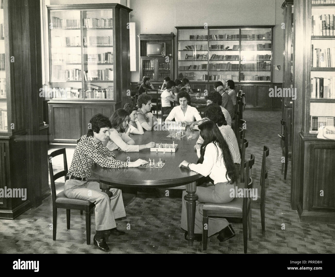 I ragazzi giocare a scacchi in biblioteca, Italia degli anni settanta Foto Stock