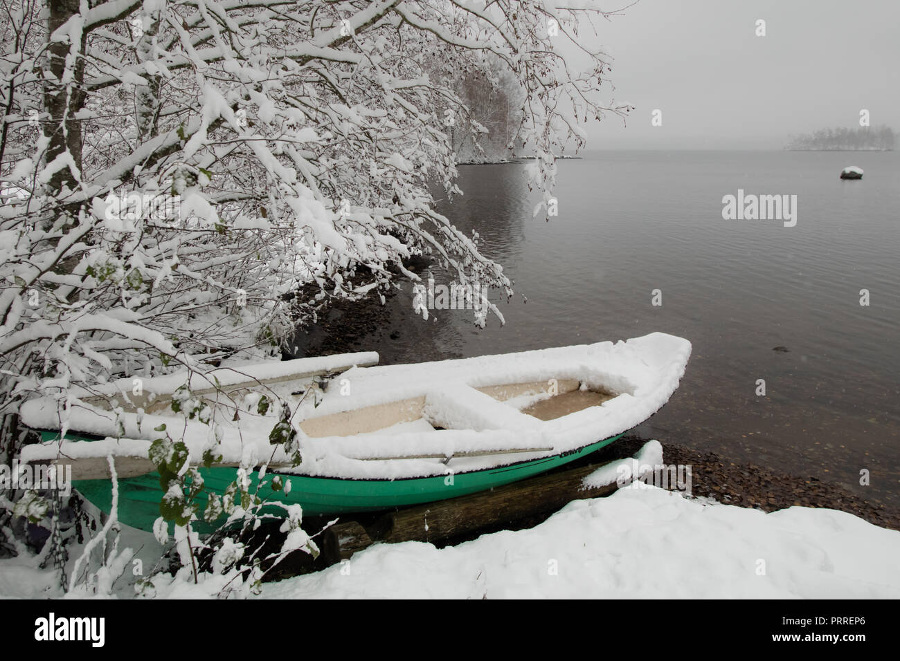 Inizio della prima neve è arrivato e ha sorpreso il proprietario di imbarcazione di questa verde barca a remi Foto Stock