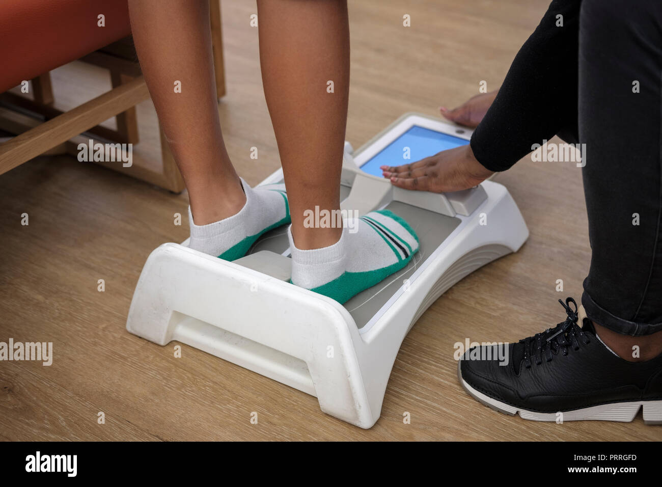 Ragazzo ha i suoi piedi misurata con Brannock elettronico dispositivo per determinare la misura della scarpa in un negozio di scarpe Foto Stock