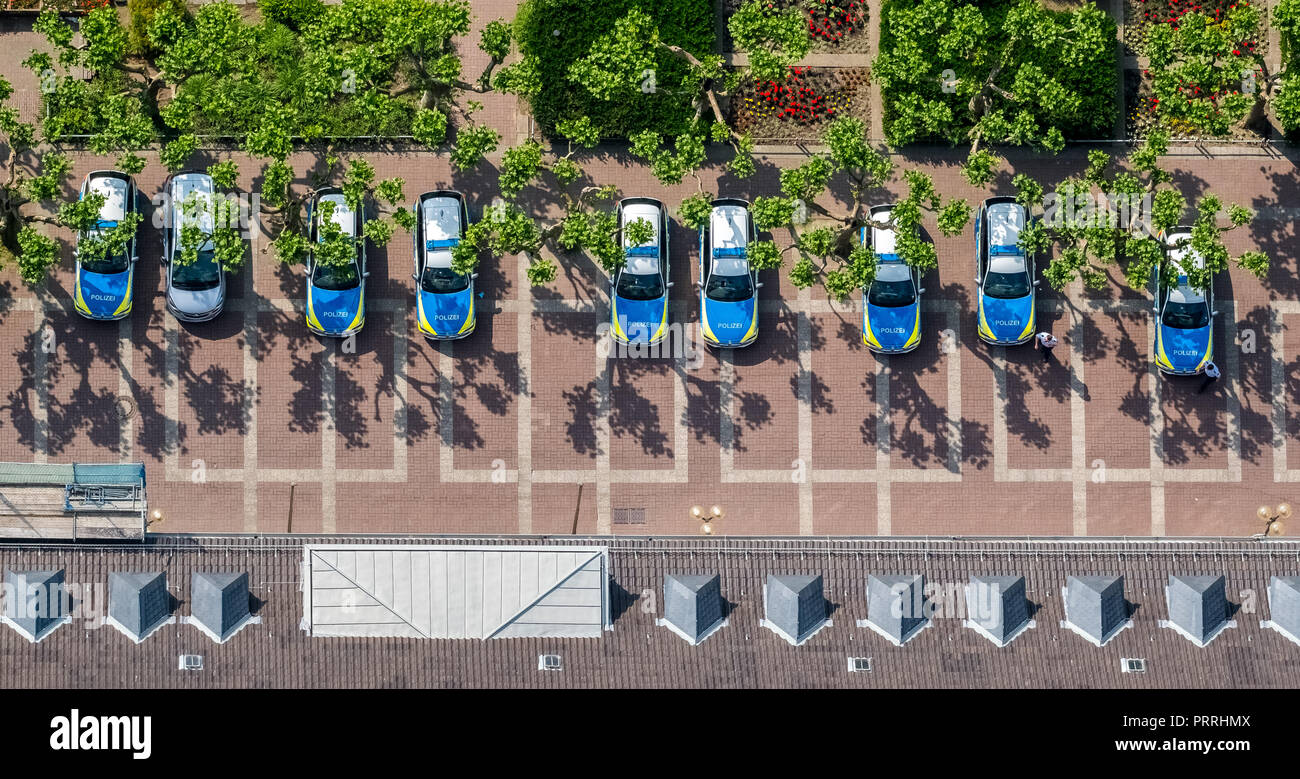 Parcheggio di fronte alla sede della polizia di Oberhausen, blu e verde, schierate auto della polizia, il parcheggio con alberi Foto Stock