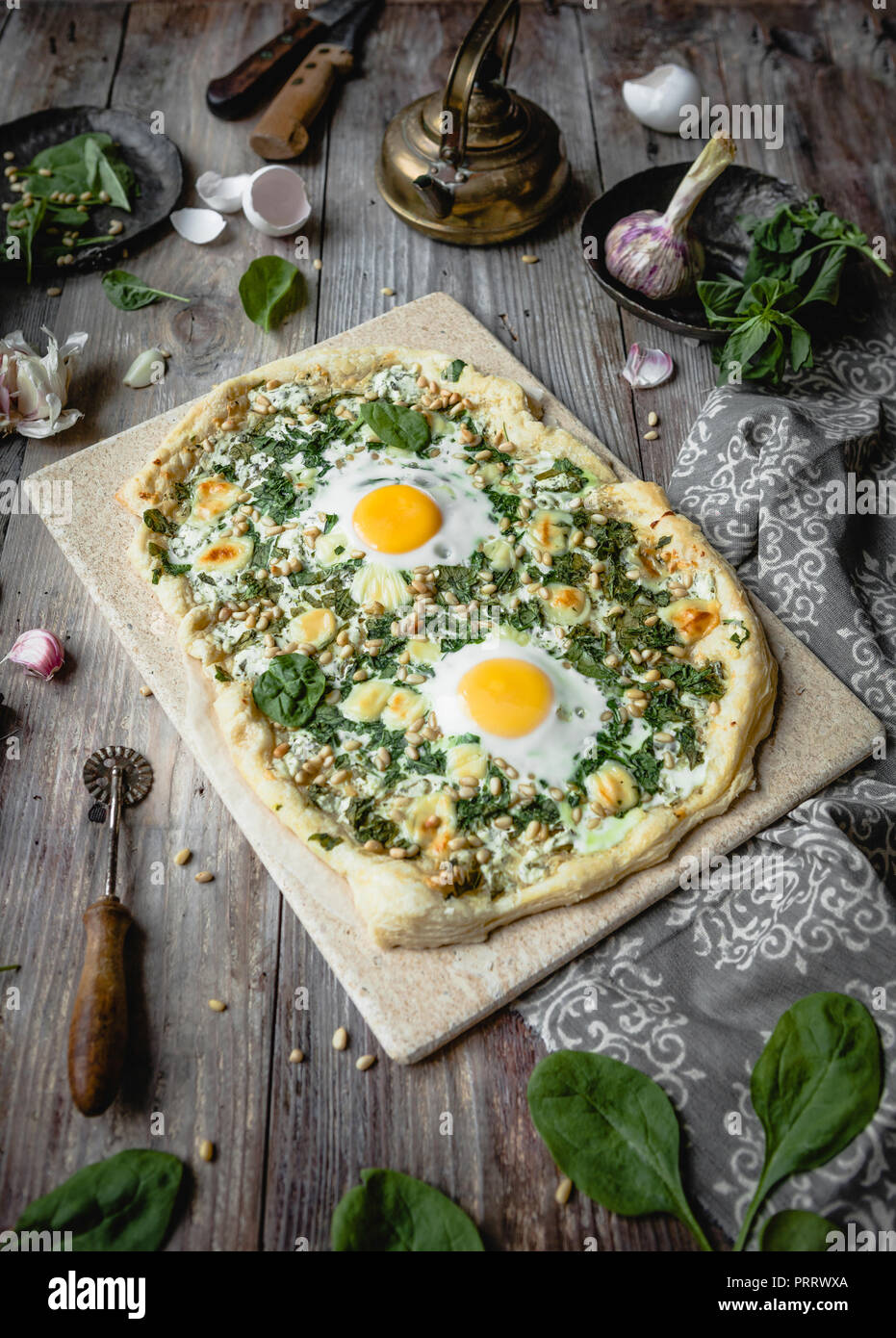 Una deliziosa pizza fatta in casa con le uova e le erbe sul pannello di legno Foto Stock