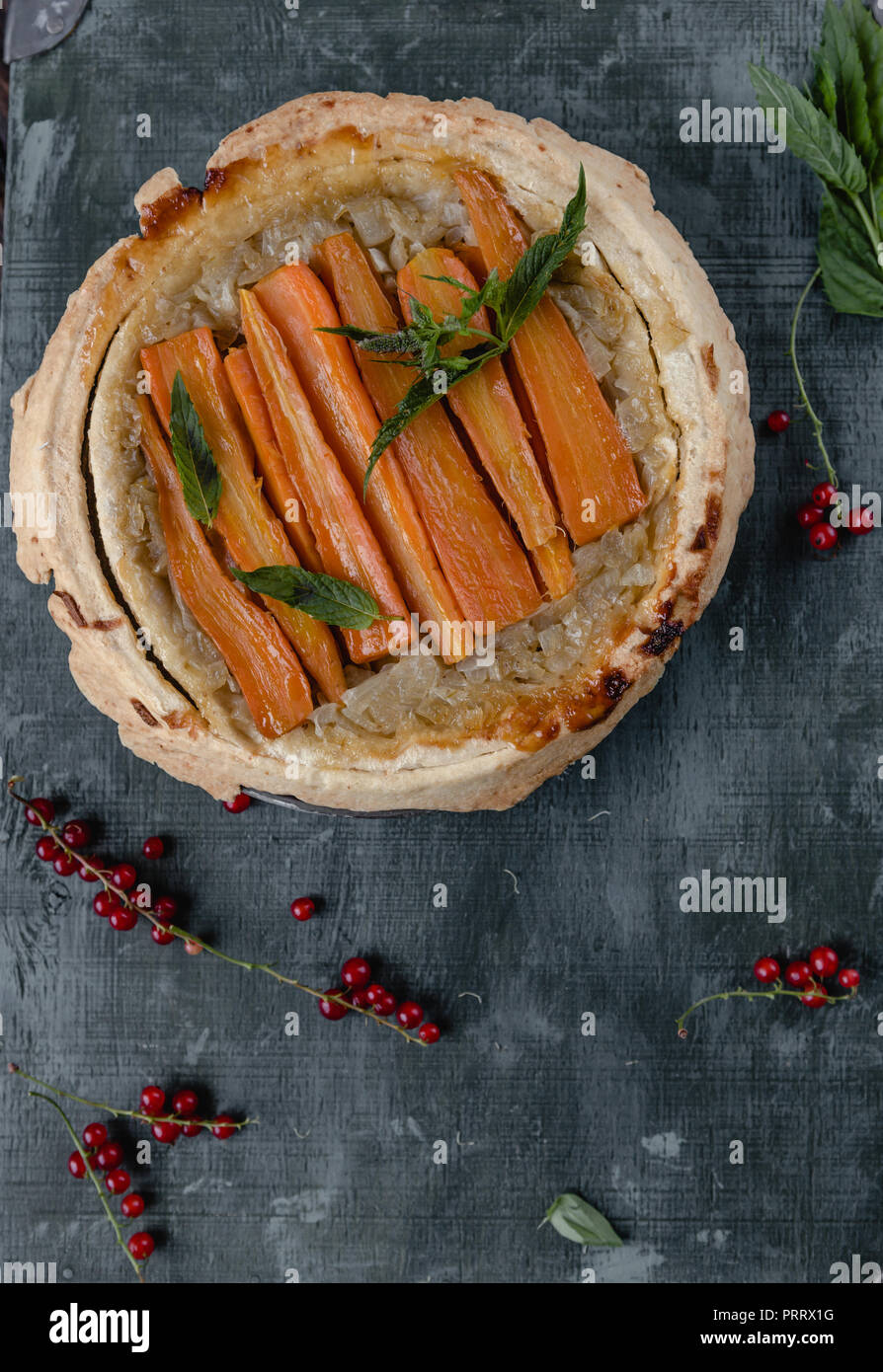 Vista superiore della squisita torta con le carote e le erbe sul tavolo di legno Foto Stock