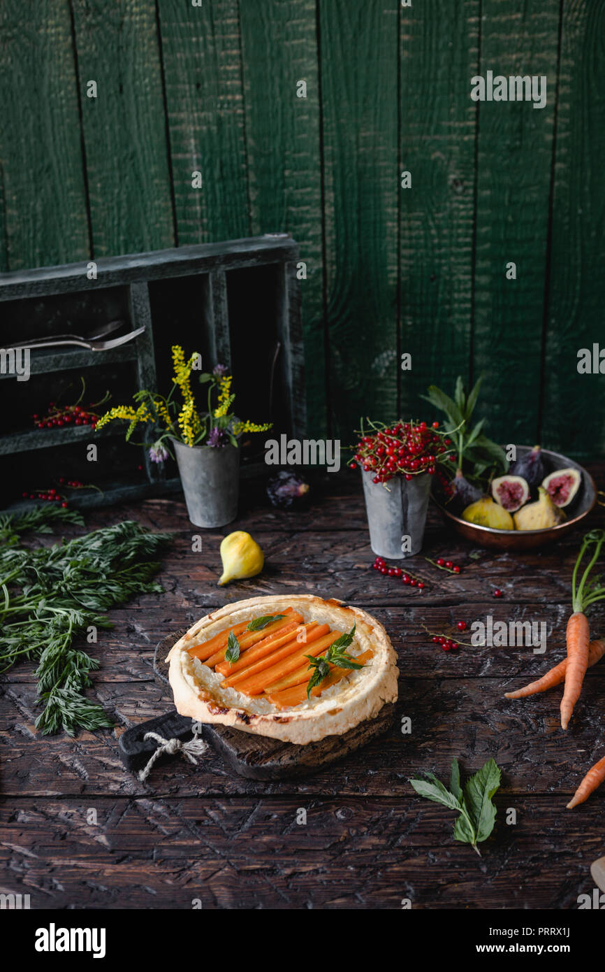 Gustosa torta con le carote e le erbe in legno tavolo rustico Foto Stock