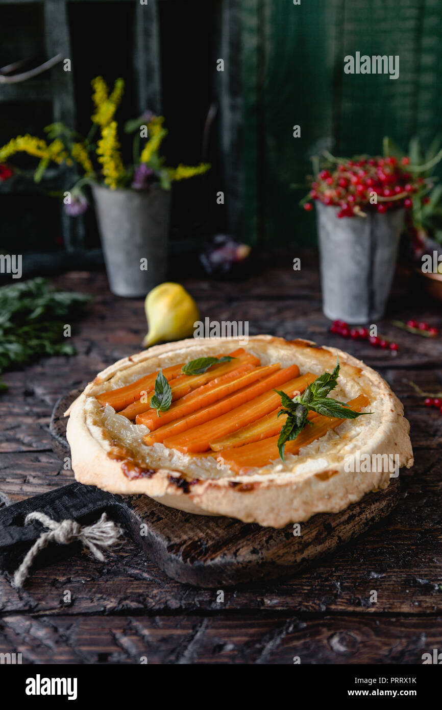 Cuocere la torta deliziosa con le carote e le erbe sul tavolo di legno Foto Stock